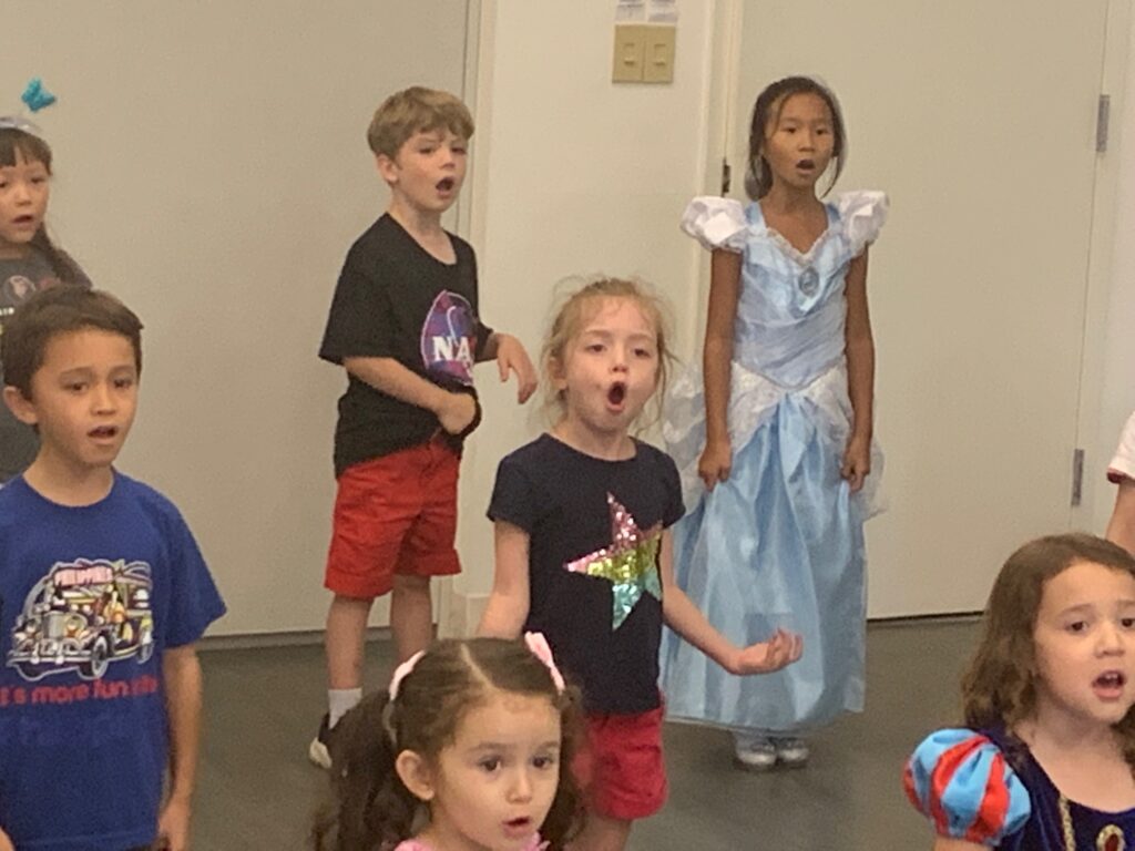 A group of students singing in performance for their parents.